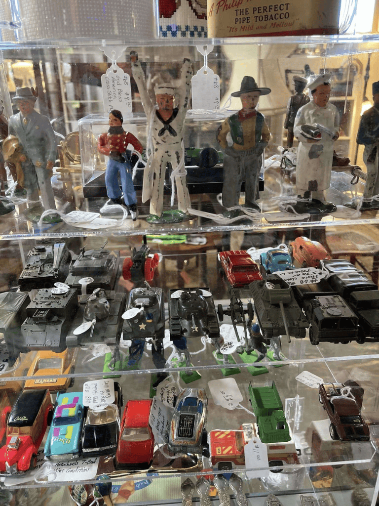 Vintage miniature figurines and toy vehicles display at QuestForDirections antique shop.