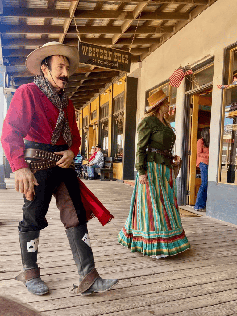 Friendly Western-themed performers at tombstone dining hall and western edge sign.