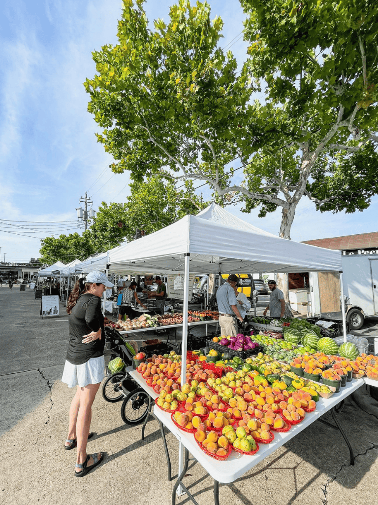 Fresh organic fruits at local farmers market on sunny day.