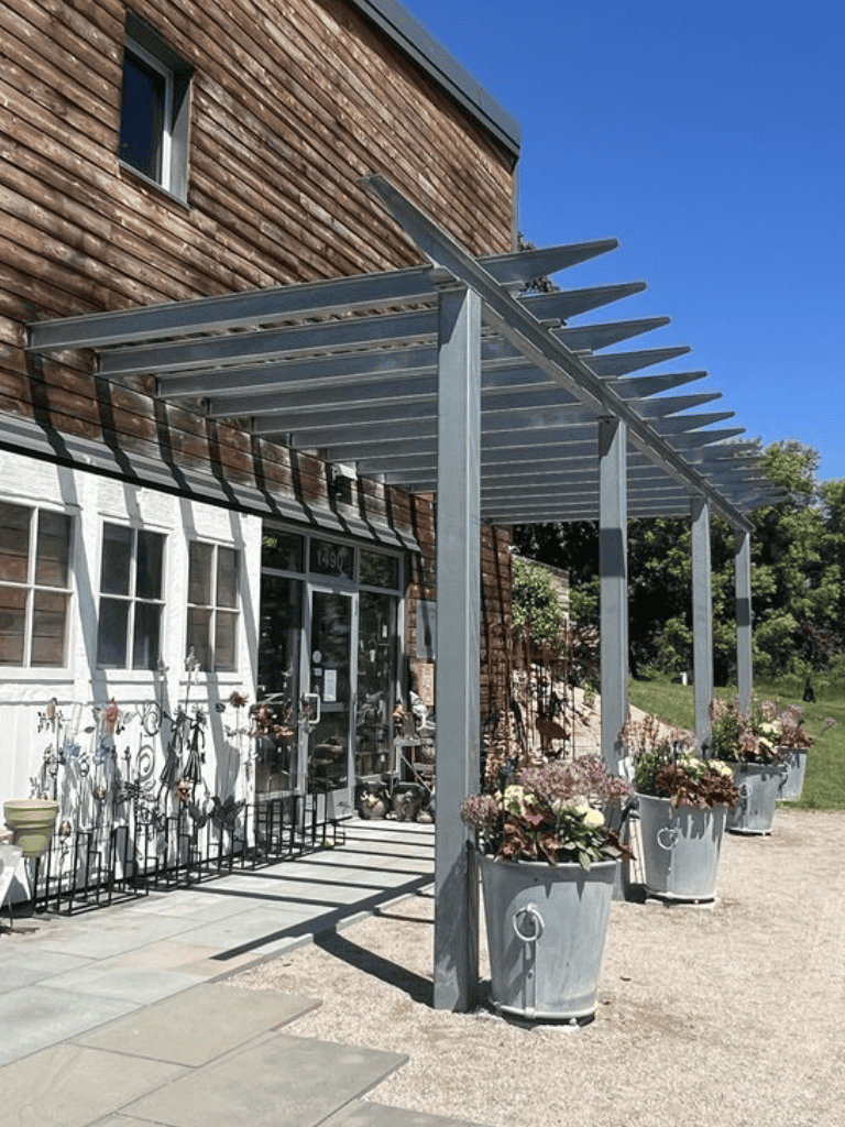 Charming outdoor entrance with potted plants at Quest for Directions shop, rustic vibe.