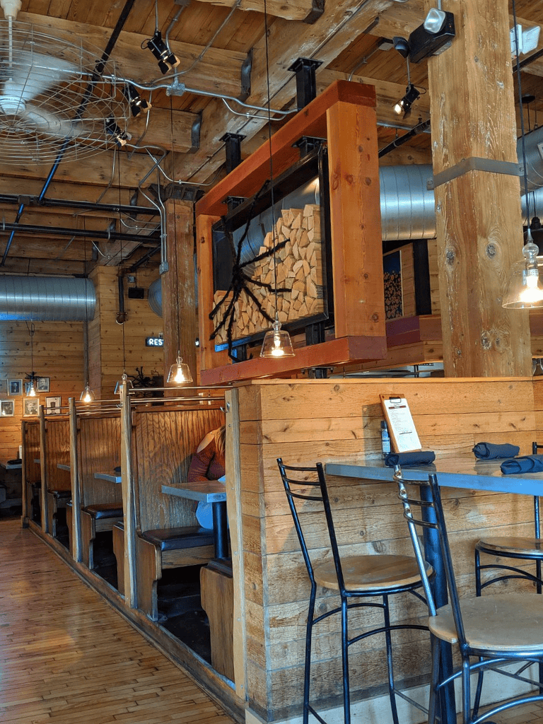 Wooden rustic interior of a cozy restaurant with a unique wood log decor element.