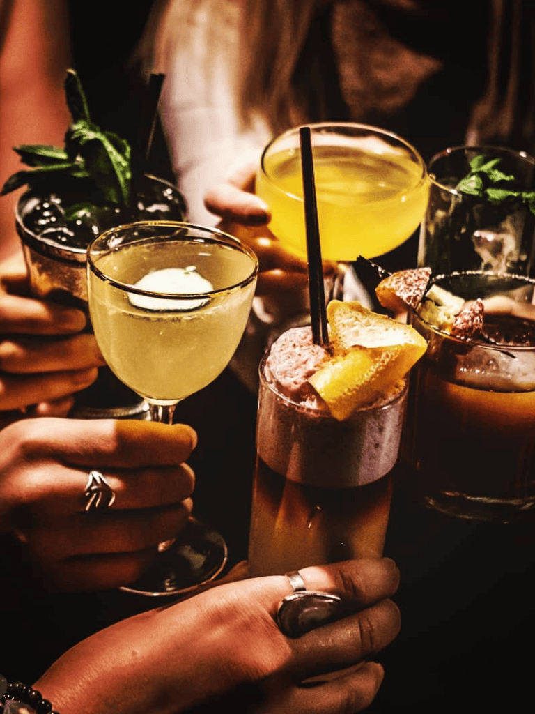 Colorful variety of cocktails in a lively social setting.