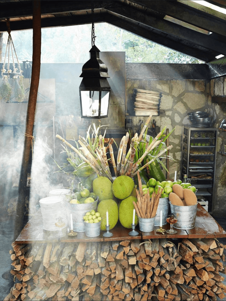 Fresh tropical fruits and vegetables in a rustic kitchen setting for healthy eating and local market shopping.