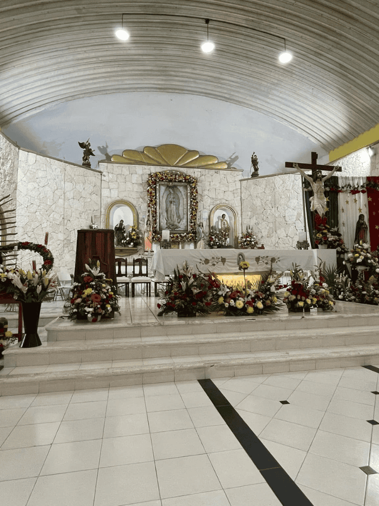 Altar decorated with flowers and religious icons in a church interior for worship or special ceremony.