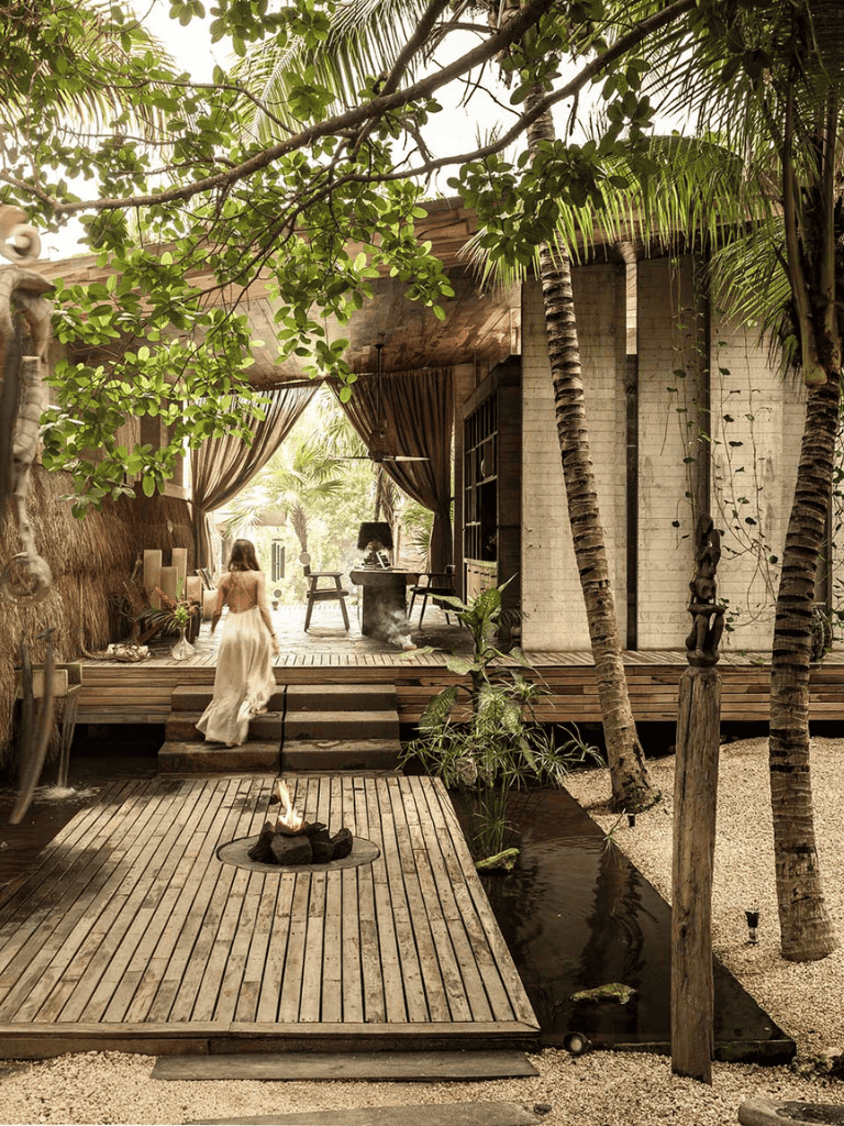 Serene tropical outdoor lounge with lush greenery and wooden deck, perfect for relaxation and nature-inspired ambiance.