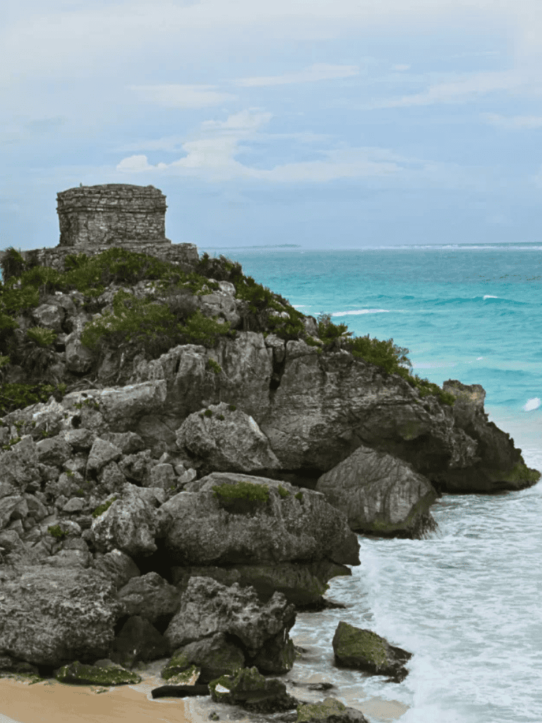 Spectacular coastal cliffs with ancient ruins overlooking turquoise ocean waters, a perfect travel destination for adventure seekers.