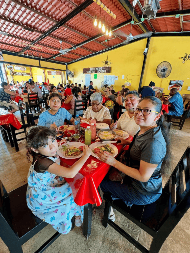 Family enjoying traditional Mexican food at a vibrant local restaurant in Honduras, welcoming atmosphere, friendly service.