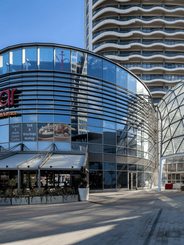 Modern glass building with curved architecture and high-rise background for QuestForDirections SEO image.