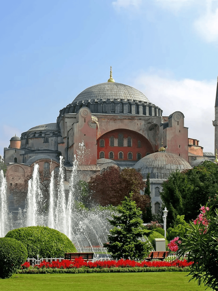 Ancient Byzantine church with domes, surrounded by greenery and fountains in Istanbul, Turkey.