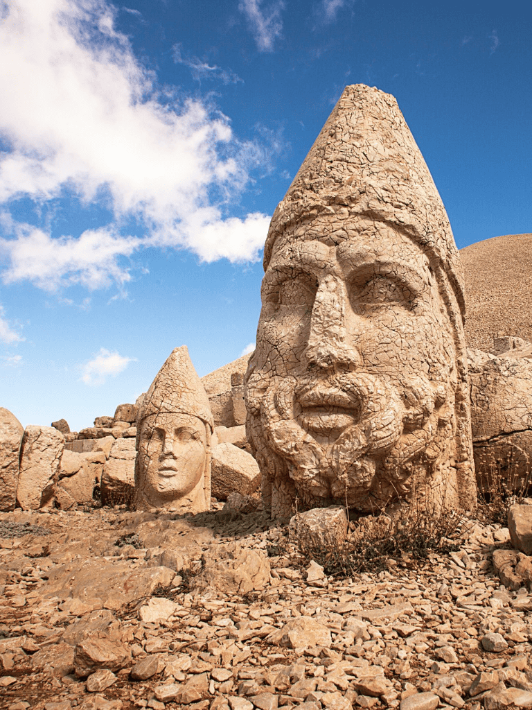 Ancient stone sculptures of warrior heads at QuestForDirections archaeological site.