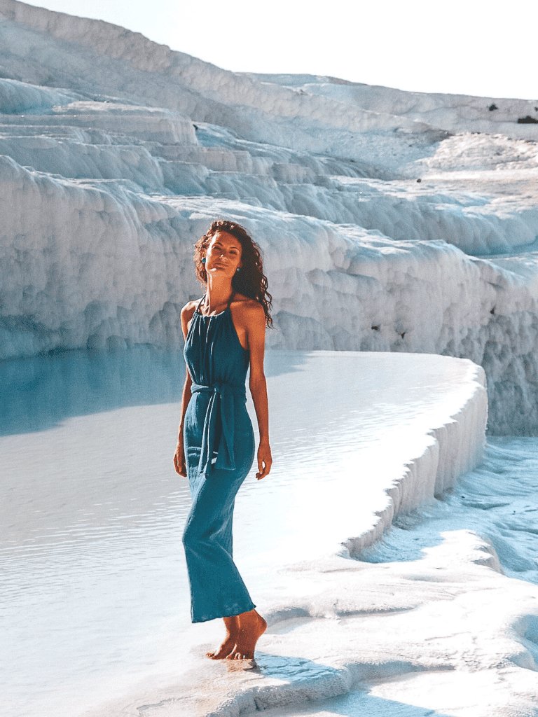 Breathtaking woman standing on glacier edge in sunny weather, exploring natural icy landscape.