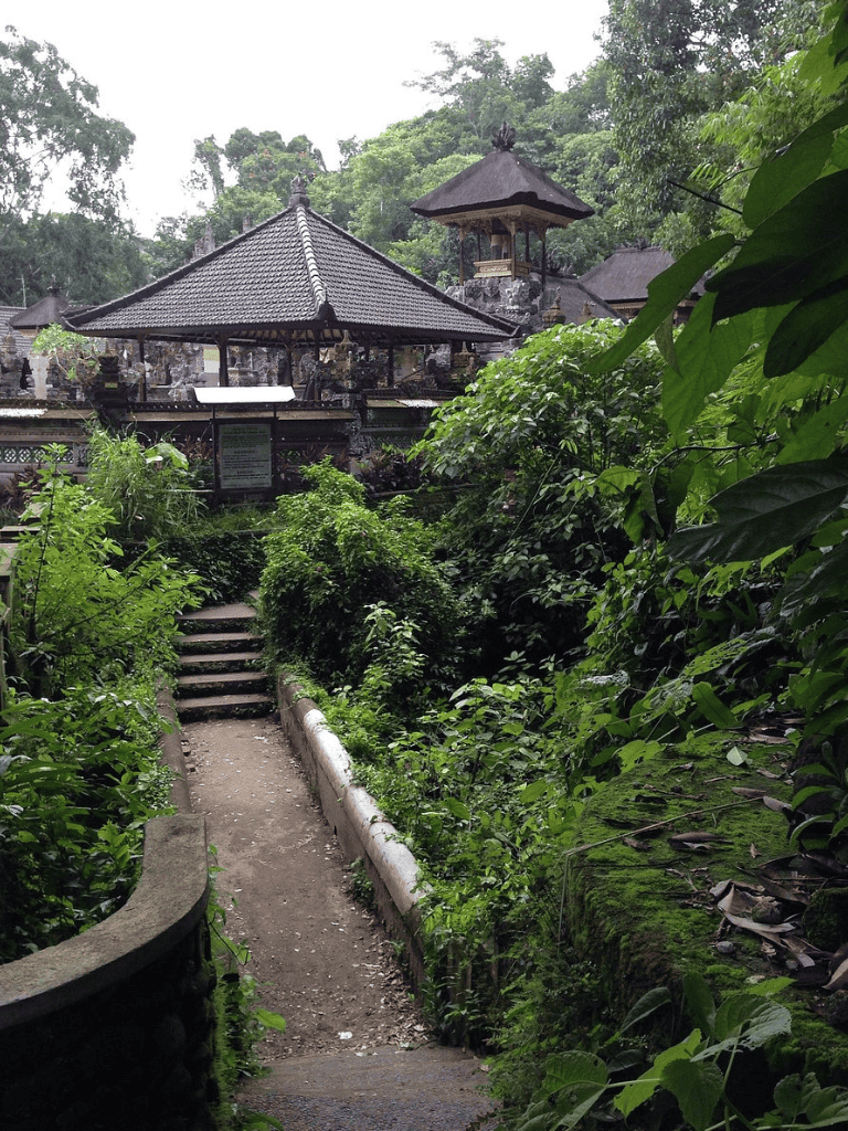 Serene traditional Balinese temple surrounded by lush greenery and tropical rainforest.