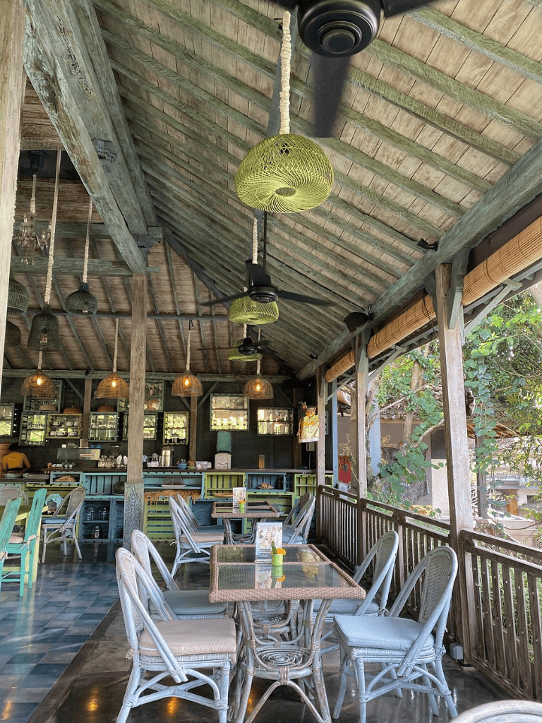 Cozy outdoor restaurant patio with rustic wooden decor and hanging lanterns, perfect for relaxing dining.