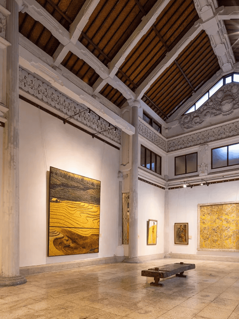 Vibrant art gallery featuring contemporary paintings and sculptures in an elegant architectural space.