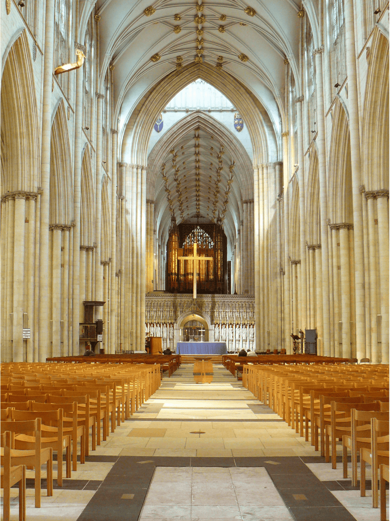Elegant Gothic cathedral interior with high vaulted ceilings and wooden pews.