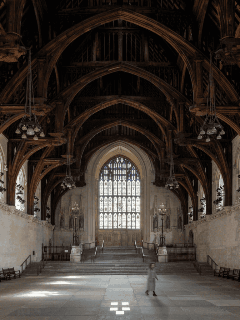 8the interior of a historic church with high vaulted wooden ceilings, large stained glass windows, and grand stone staircase.