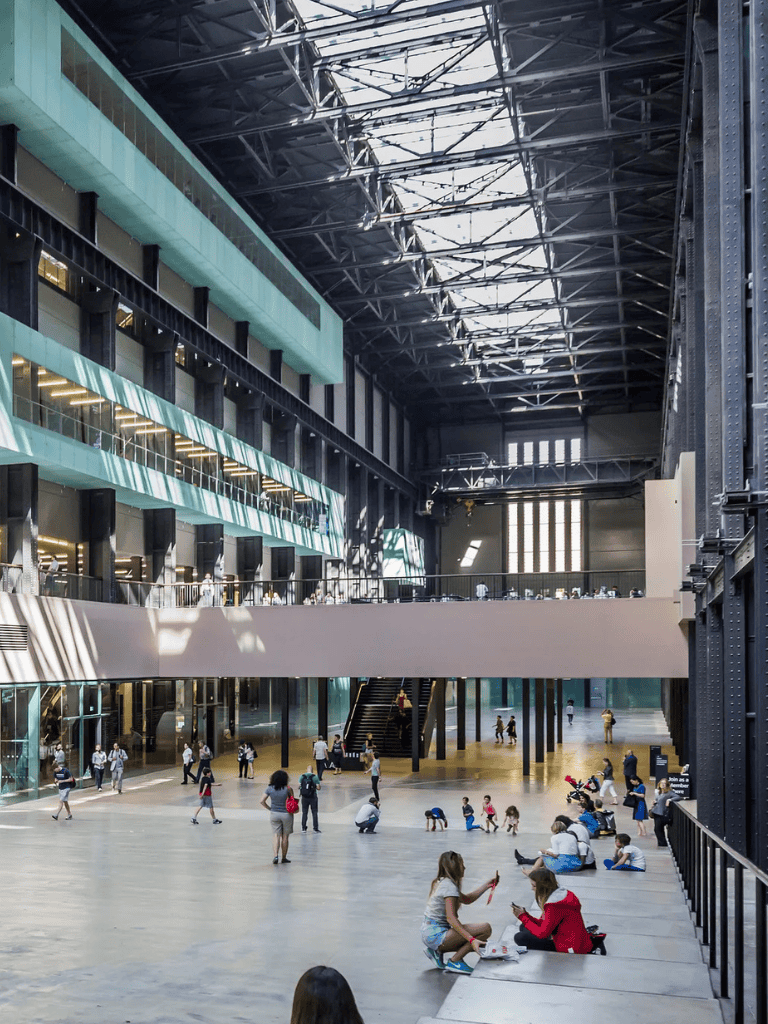 Modern transit hub interior with travelers, large open space, and striking industrial architecture.