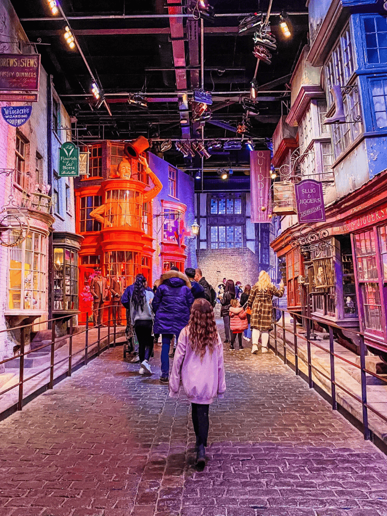 Colorful interactive indoor street scene at QuestForDirections amusement park, bustling with kids and families exploring shops and attractions.