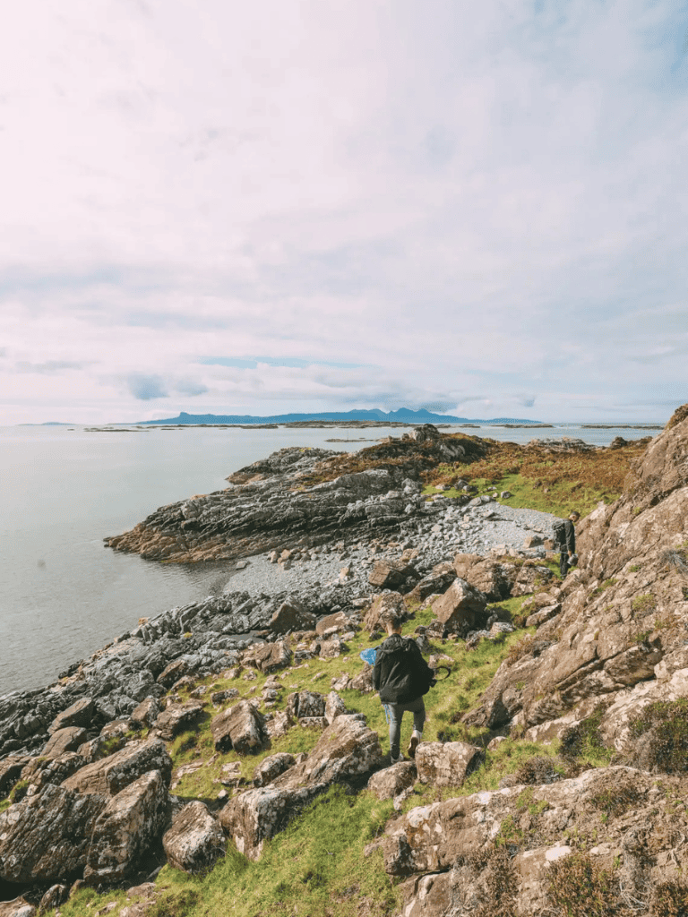 Scenic coastal hike on rocky shoreline with hikers exploring seaside terrain.