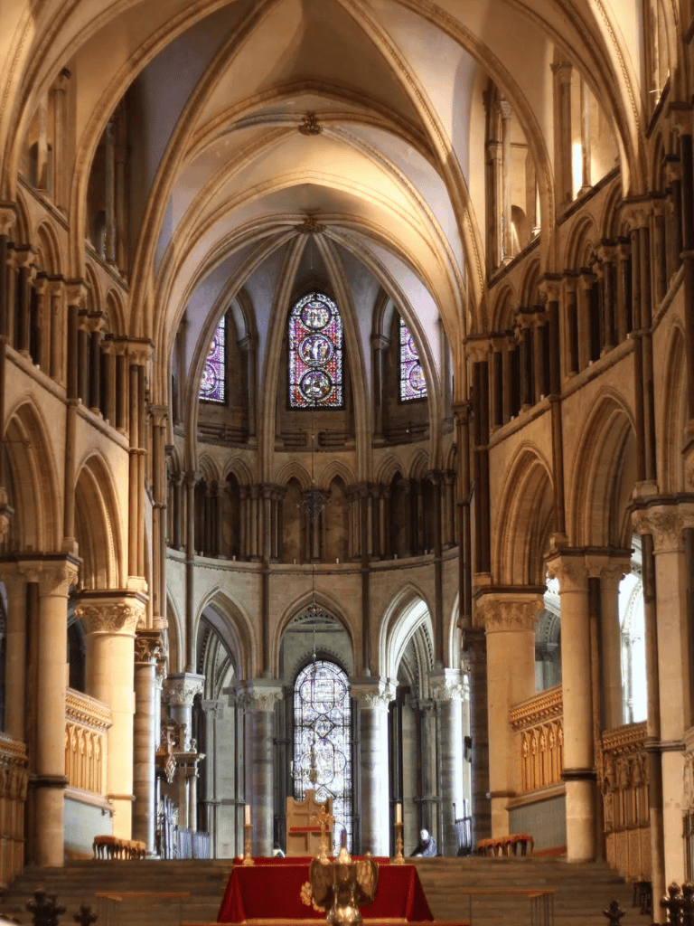 Intricate Gothic cathedral interior with stained glass windows and ornate architectural details.