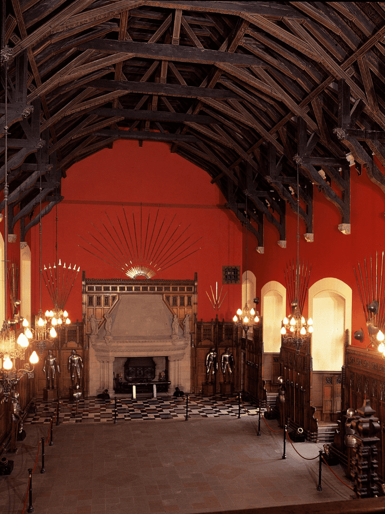 Seating inside historic castle with stone fireplace and wooden beams.