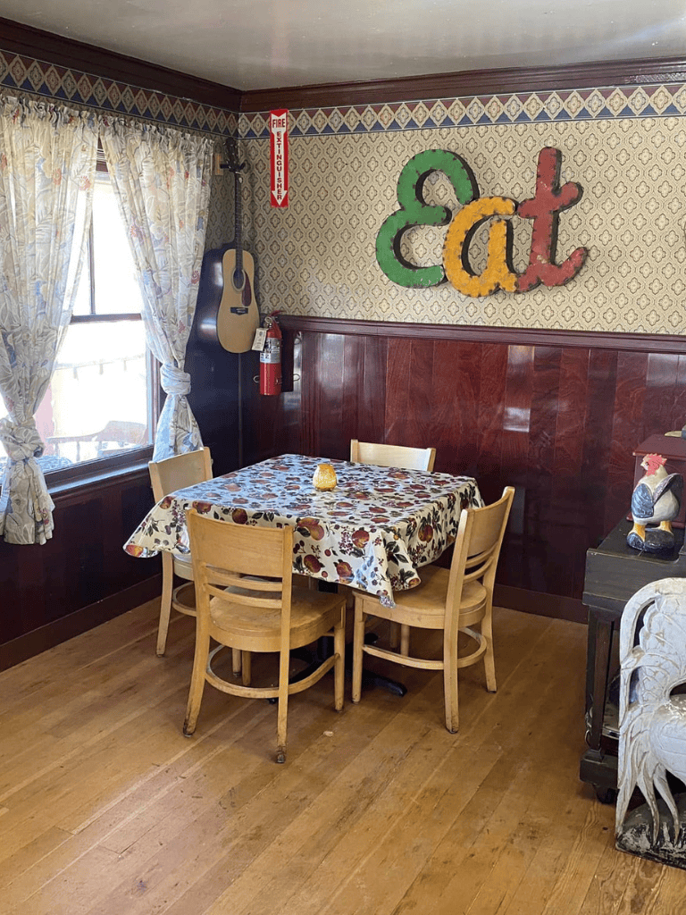 Colorful "Eat" sign on vintage patterned wall in cozy restaurant interior.
