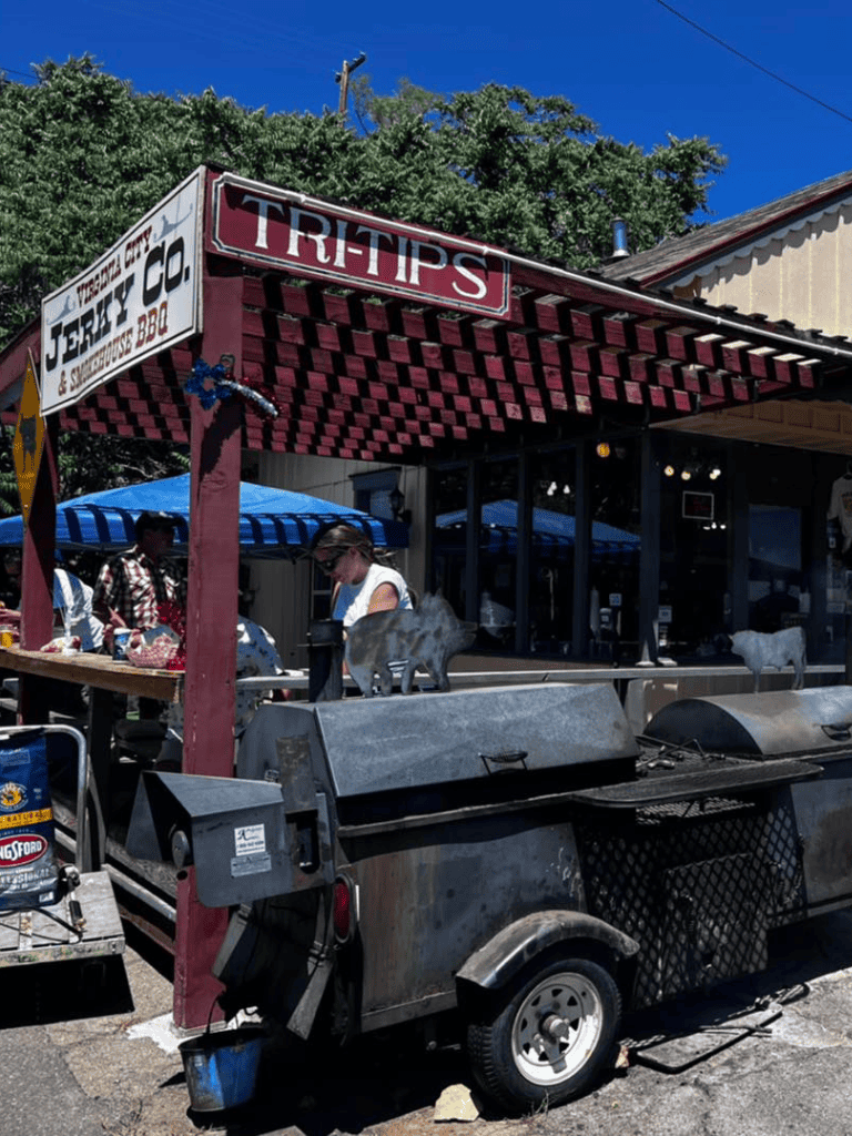 Juicy BBQ food stand at Tritips restaurant in a small town, outdoor setup with customers enjoying barbecue.