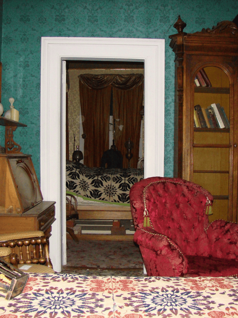 Ornate vintage living room with antique furniture and floral patterned textiles.
