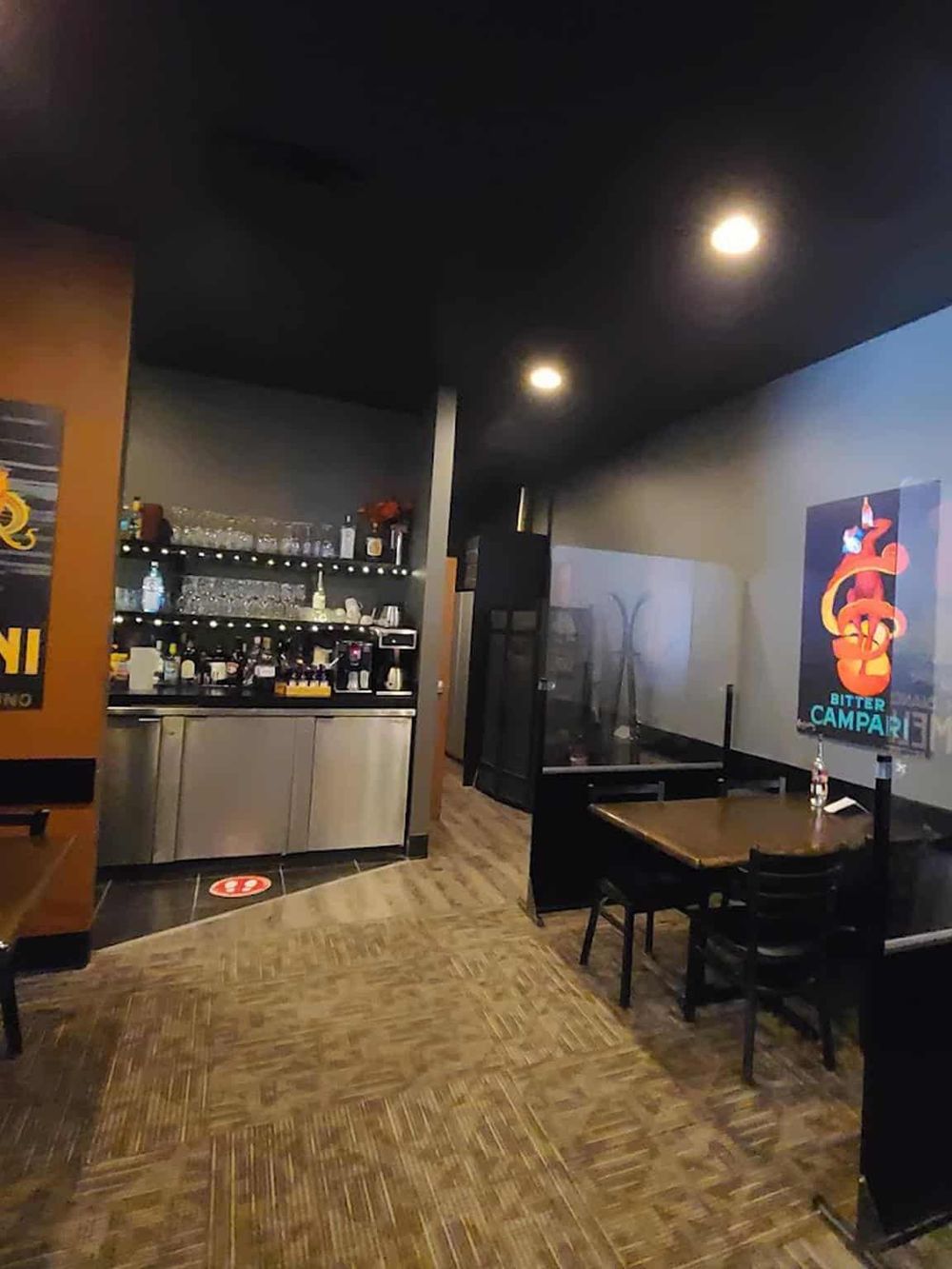Cozy bar interior with modern decor, featuring a well-stocked drink station and vibrant artwork. Perfect for socializing and nightlife experience.