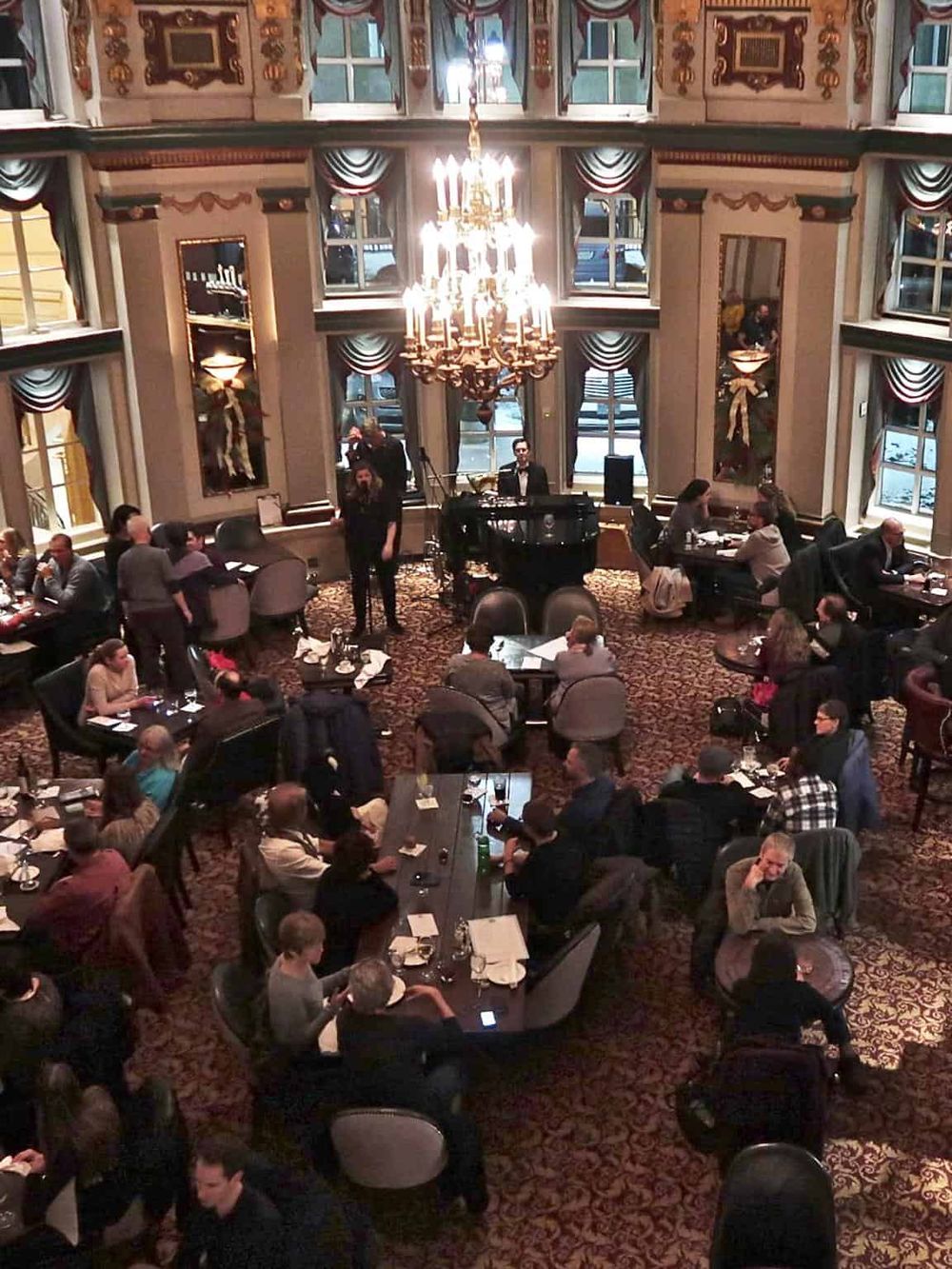 Elegant hotel lounge with live jazz music, luxurious chandeliers, and guests enjoying a sophisticated evening.