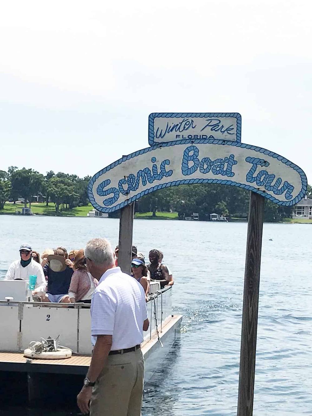 Colorful Sonic Boat Tour on a calm Florida lake with tourists enjoying a scenic cruise.