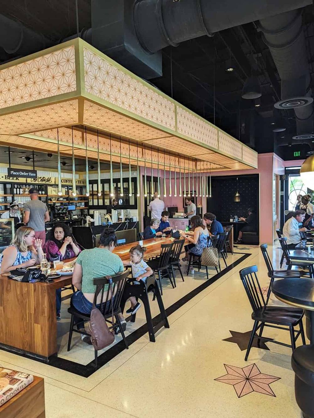 Bright cafe interior with customers dining and barista at counter, modern decor at QuestForDirections.