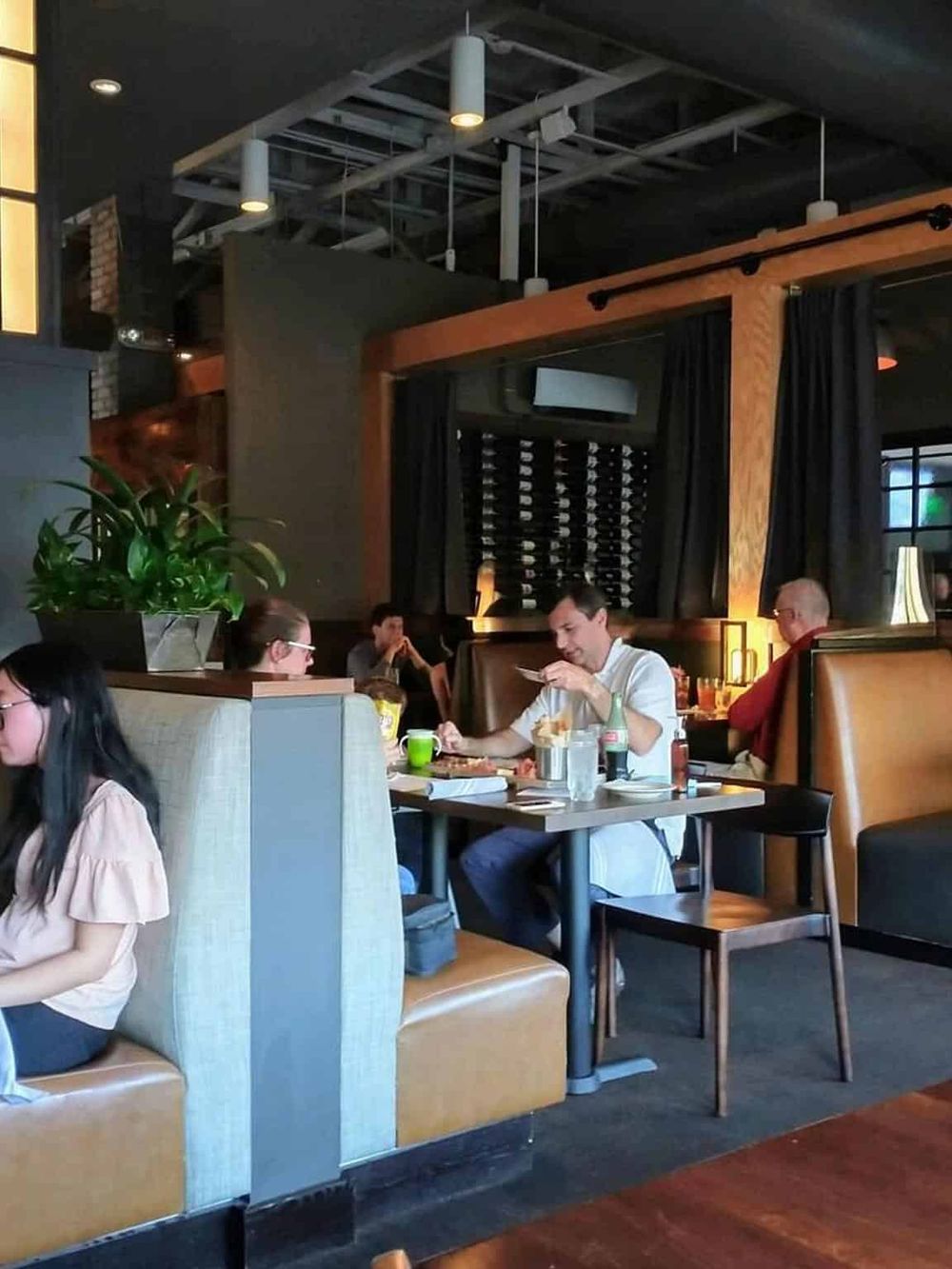 Cozy restaurant dining area with modern decor and comfortable booth seating, perfect for social gatherings and meals.