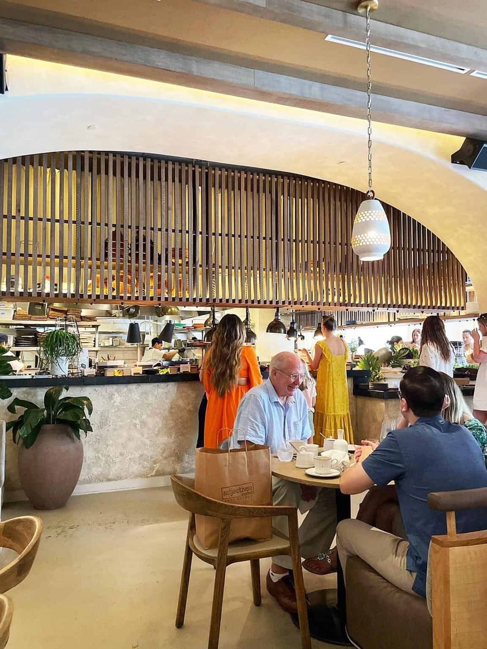 Cozy restaurant interior with modern design, warm lighting, and diverse guests enjoying dining experience.