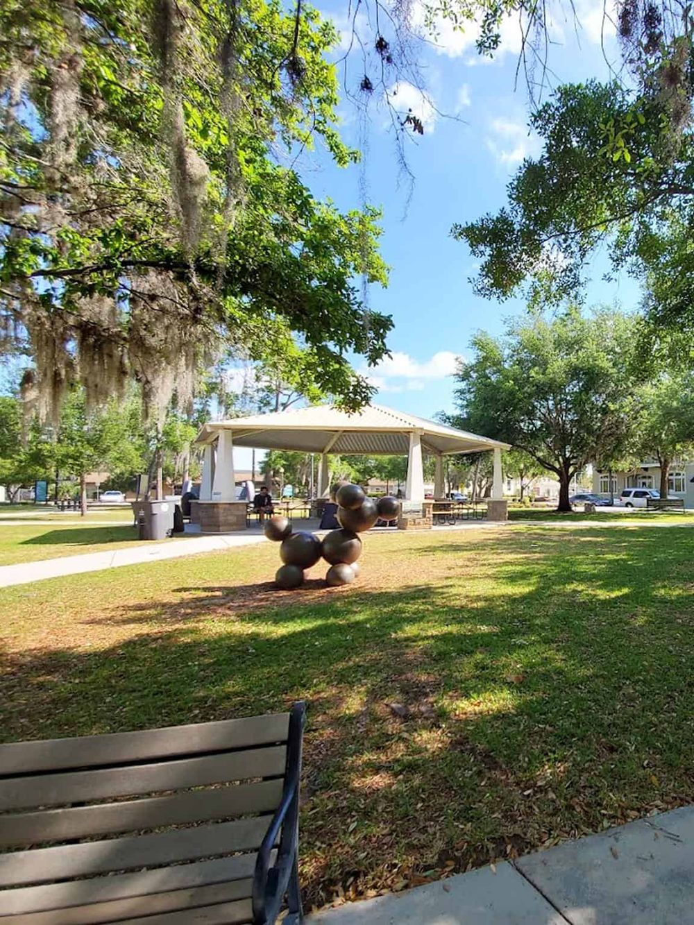 Scenic park with gazebo, sculpture, trees, and benches, perfect for outdoor relaxation and community gatherings.