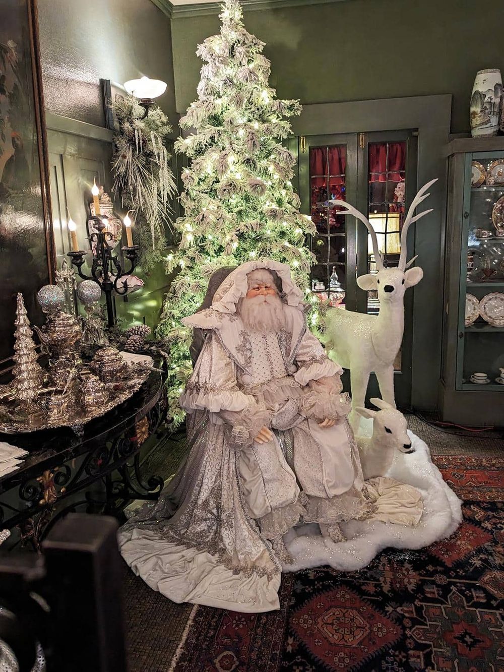 Santa Claus figurine with reindeer and Christmas tree at QuestForDirections holiday display.