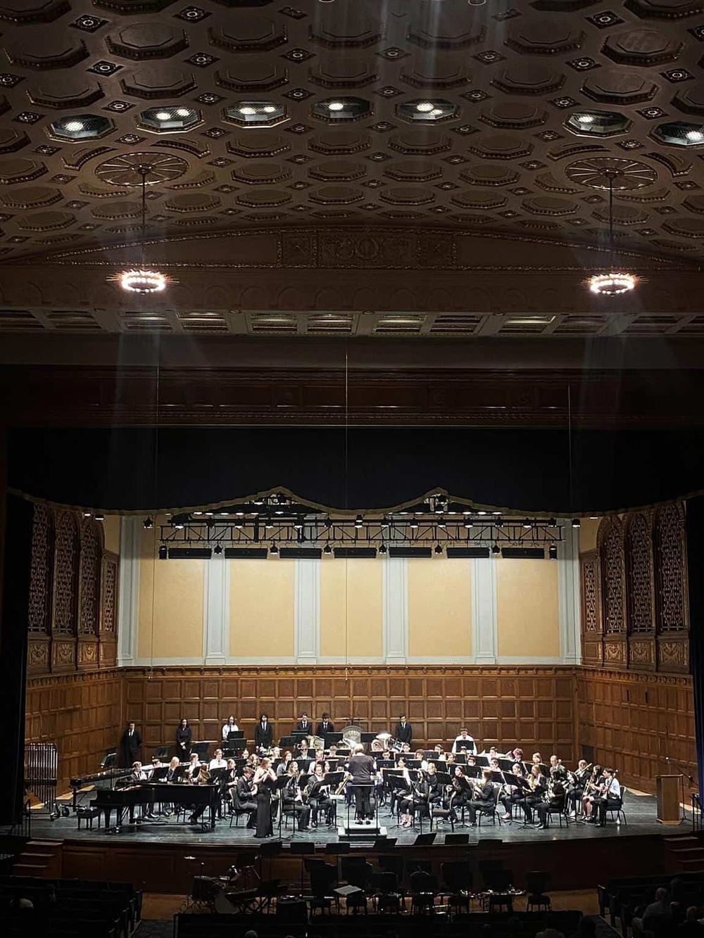 Elegant concert hall with an orchestral performance on stage, showcasing classical music ambiance.