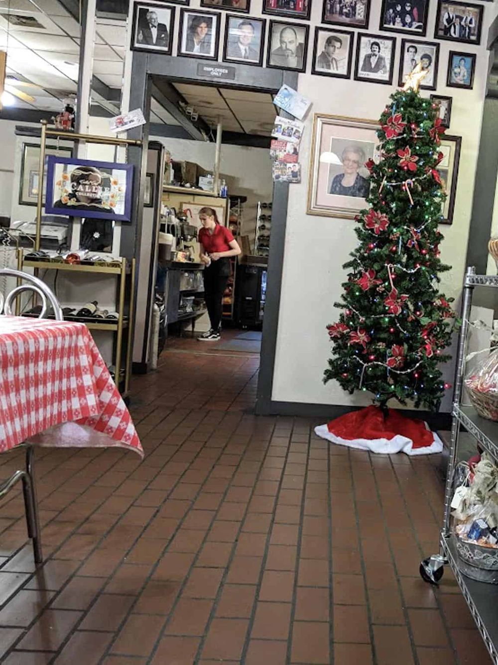 Christmas decorated tree with festive ornaments inside a cozy cafe or restaurant.