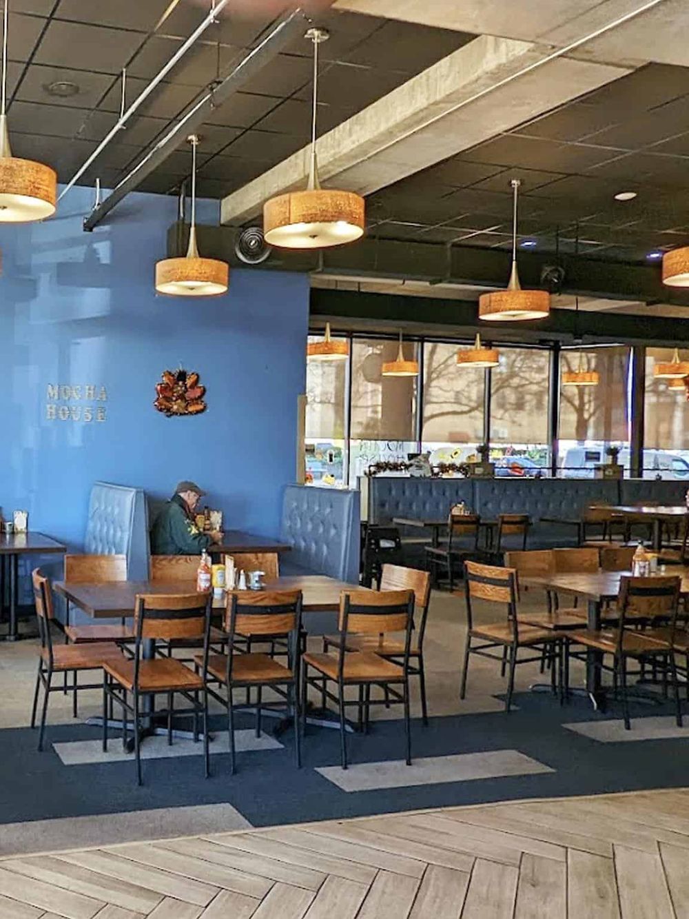 Cozy restaurant interior with wooden tables and modern lighting, perfect for family dining or casual meals.