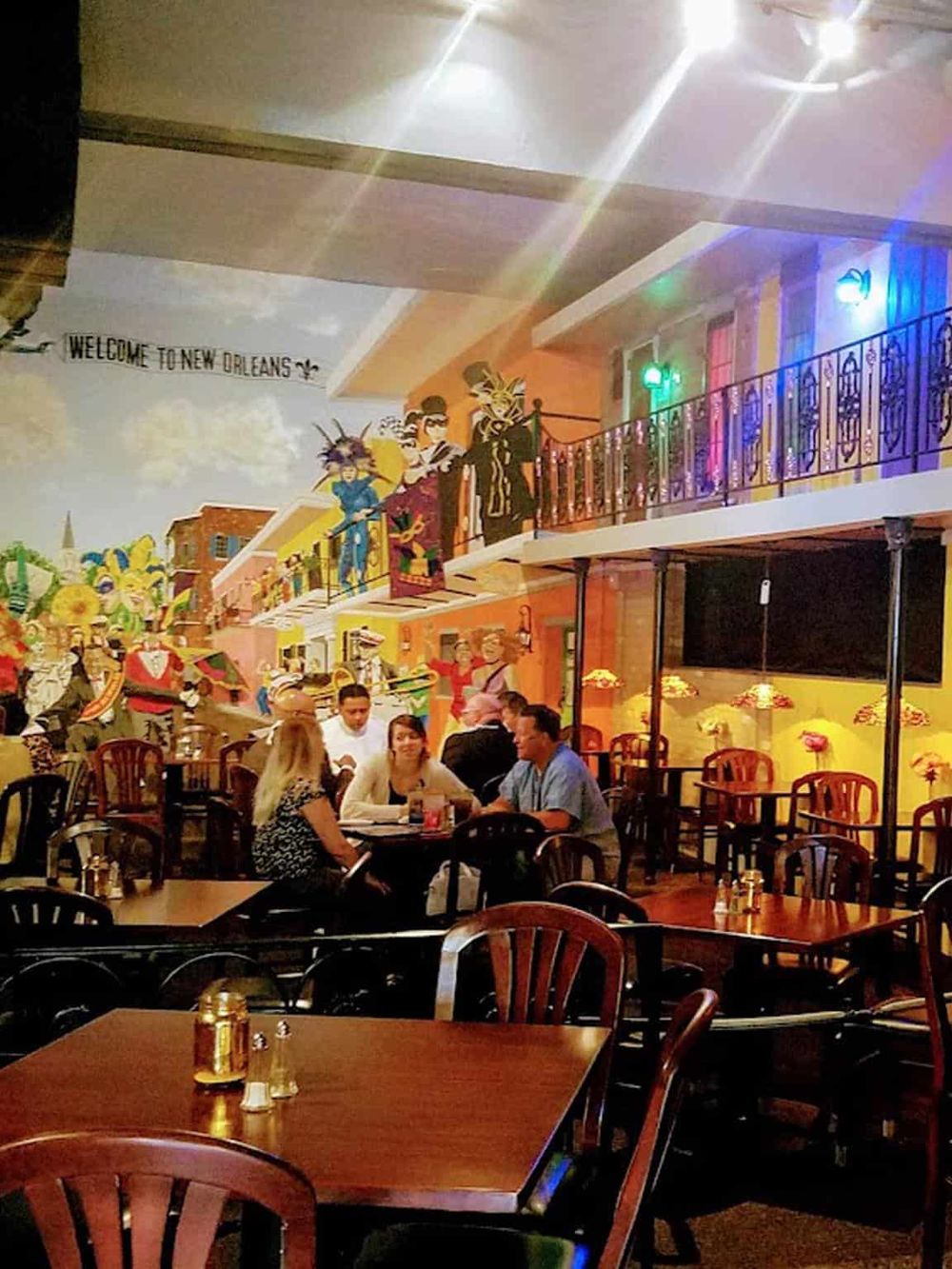 Colorful New Orleans-themed restaurant interior with vibrant wall murals and lively dining atmosphere.
