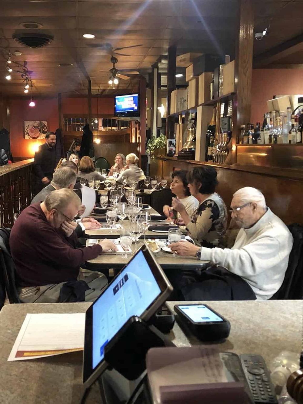 Cozy restaurant interiors with guests dining, modern decor, and warm lighting for an inviting atmosphere.