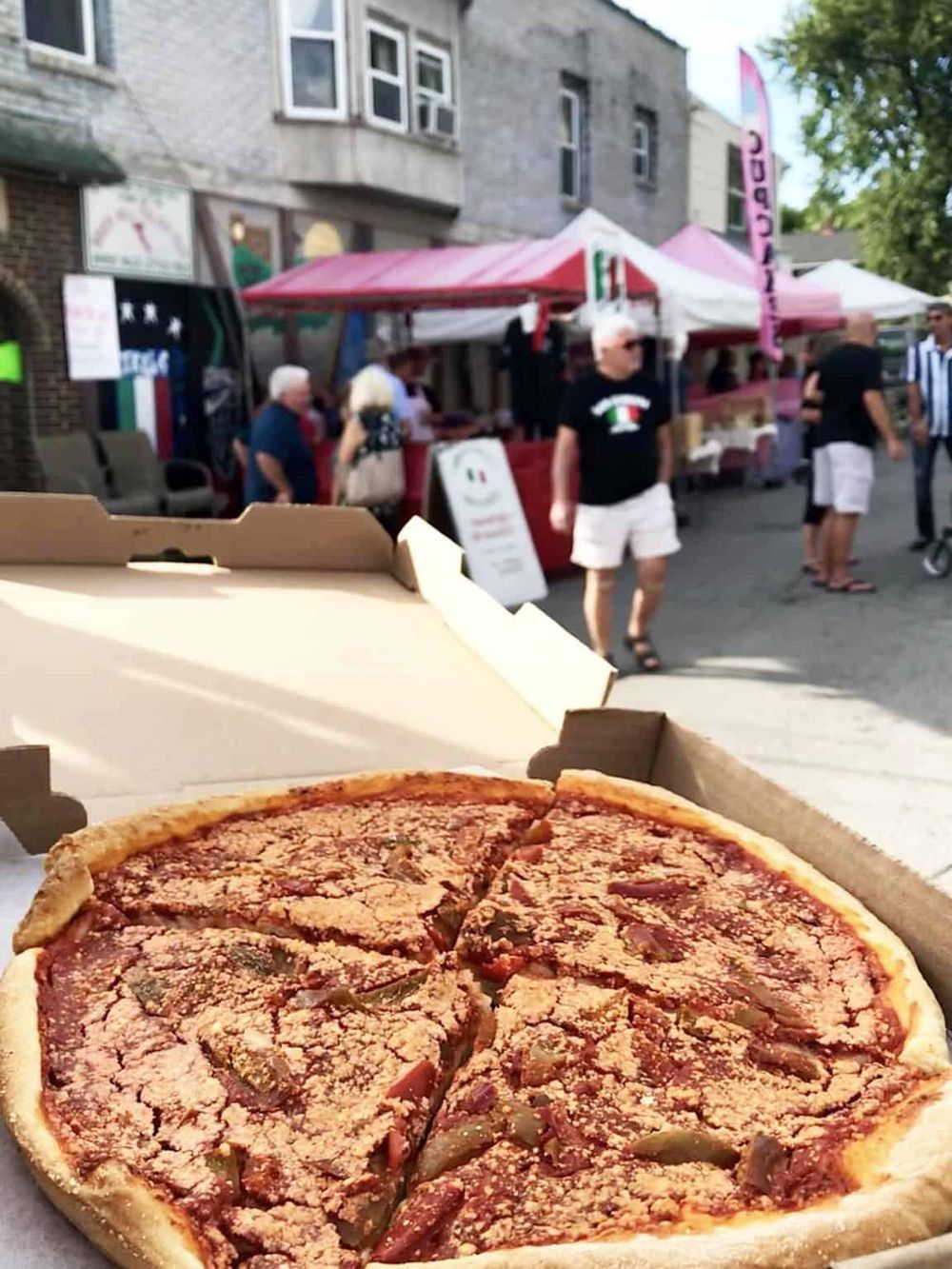 Freshly baked pizza at outdoor street food market during summer.
