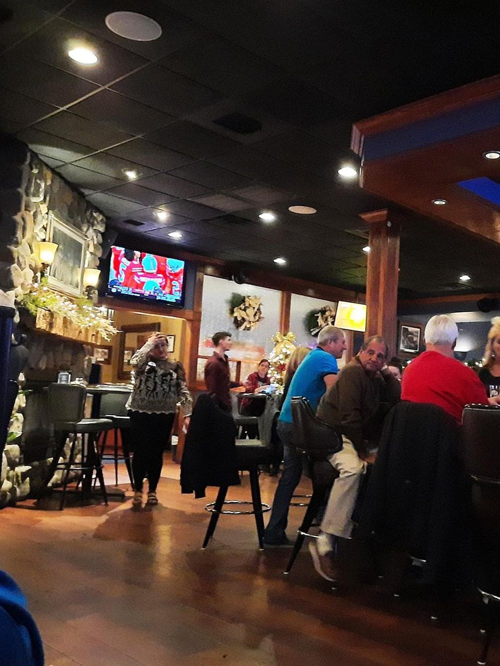 Cozy restaurant interior with customers enjoying their meals and festive holiday decorations.