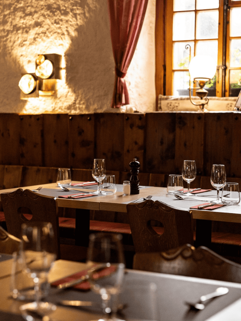 Cozy rustic restaurant interior with wooden furniture and ambient lighting, perfect for dining and special occasions.