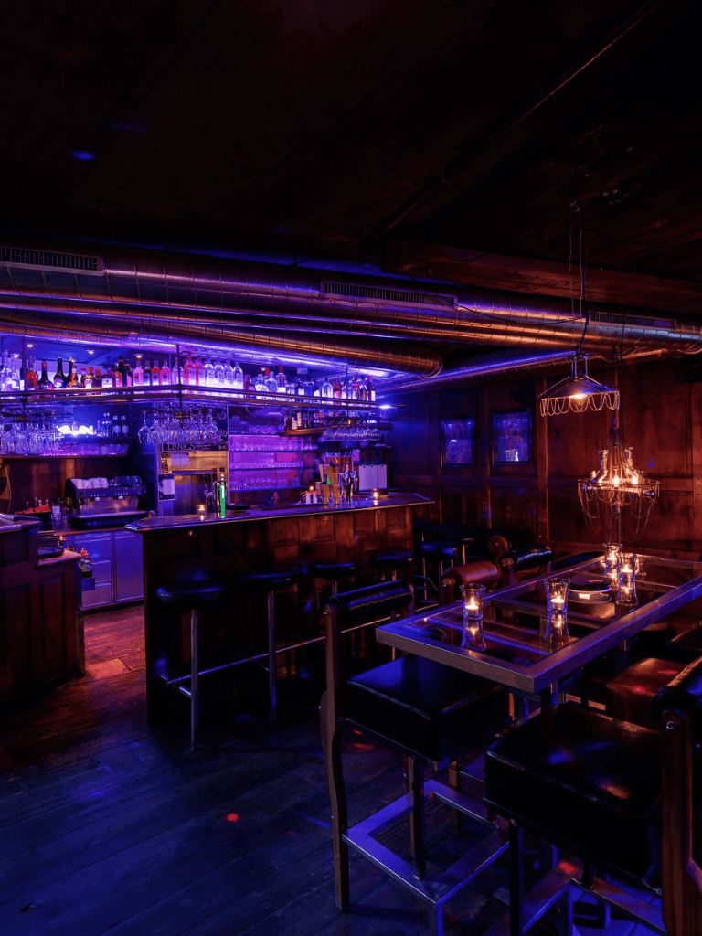 Vibrant bar interior with colorful LED lighting and modern decor, perfect for nightlife and social gatherings.