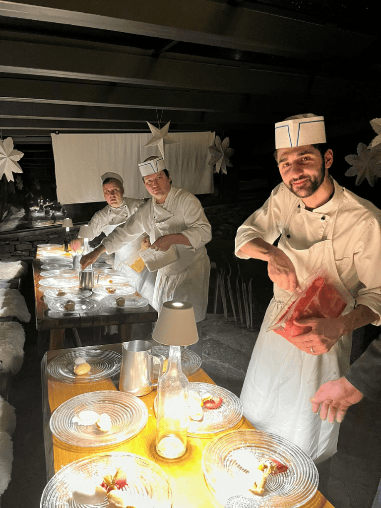 Elegant chefs preparing desserts at a cozy, festive kitchen party space.