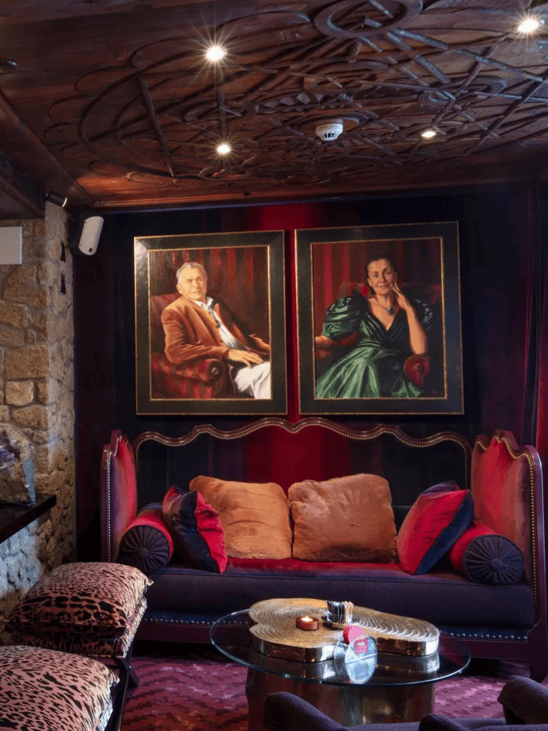 Elegant lounge with framed portrait paintings, plush cushions, and cozy ambiance at QuestForDirections.