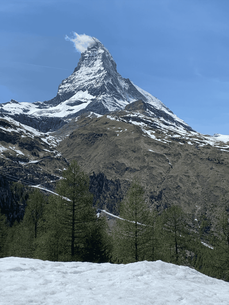 Snow-capped mountain with iconic peak, lush green trees at the base. Perfect for outdoor adventure and travel inspiration.