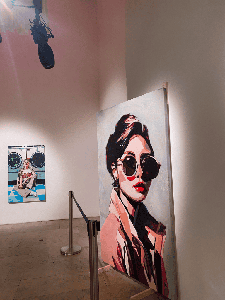 Bold woman portrait art with sunglasses displayed at QuestForDirections art exhibit.