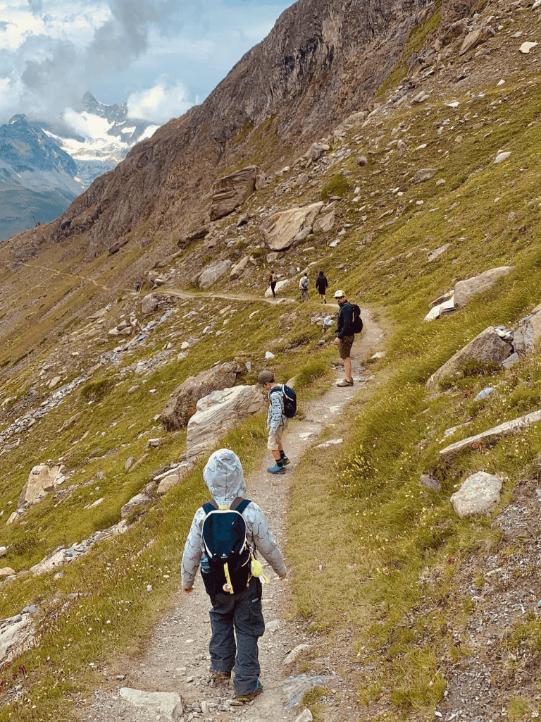 Hiking trail in the mountains with children and adults exploring scenic nature terrain.